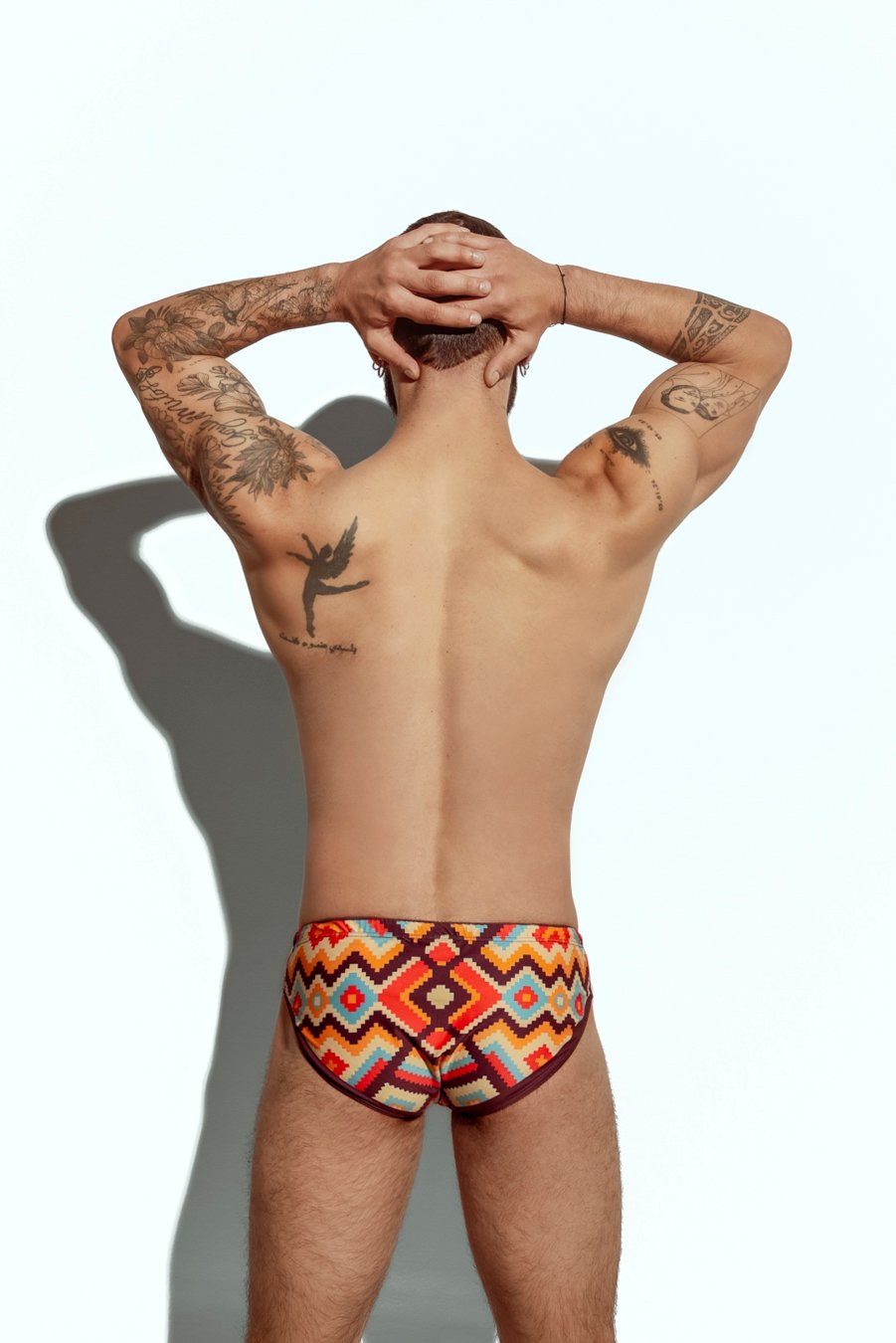 Men's swim brief featuring a bold zigzag pattern in red, orange, and yellow, ideal for gay men seeking stylish and eye-catching swimwear