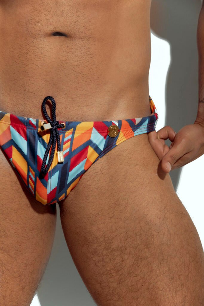 Men's swim brief with vibrant multicolor abstract pattern, perfect for gay men who love bold and unique pool and beachwear