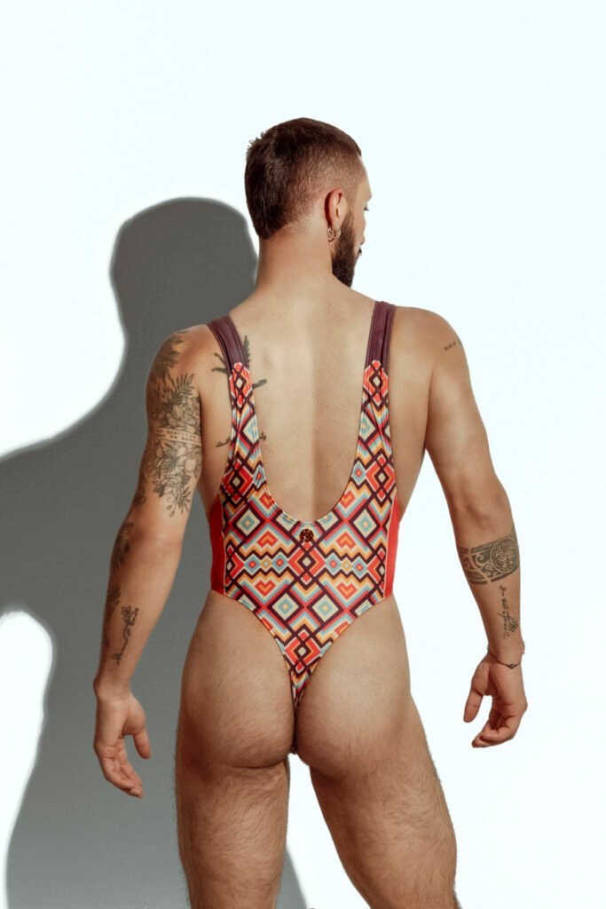 Men's high-cut swim bodysuit with orange and teal geometric pattern, designed for gay men seeking bold and fashionable swimwear