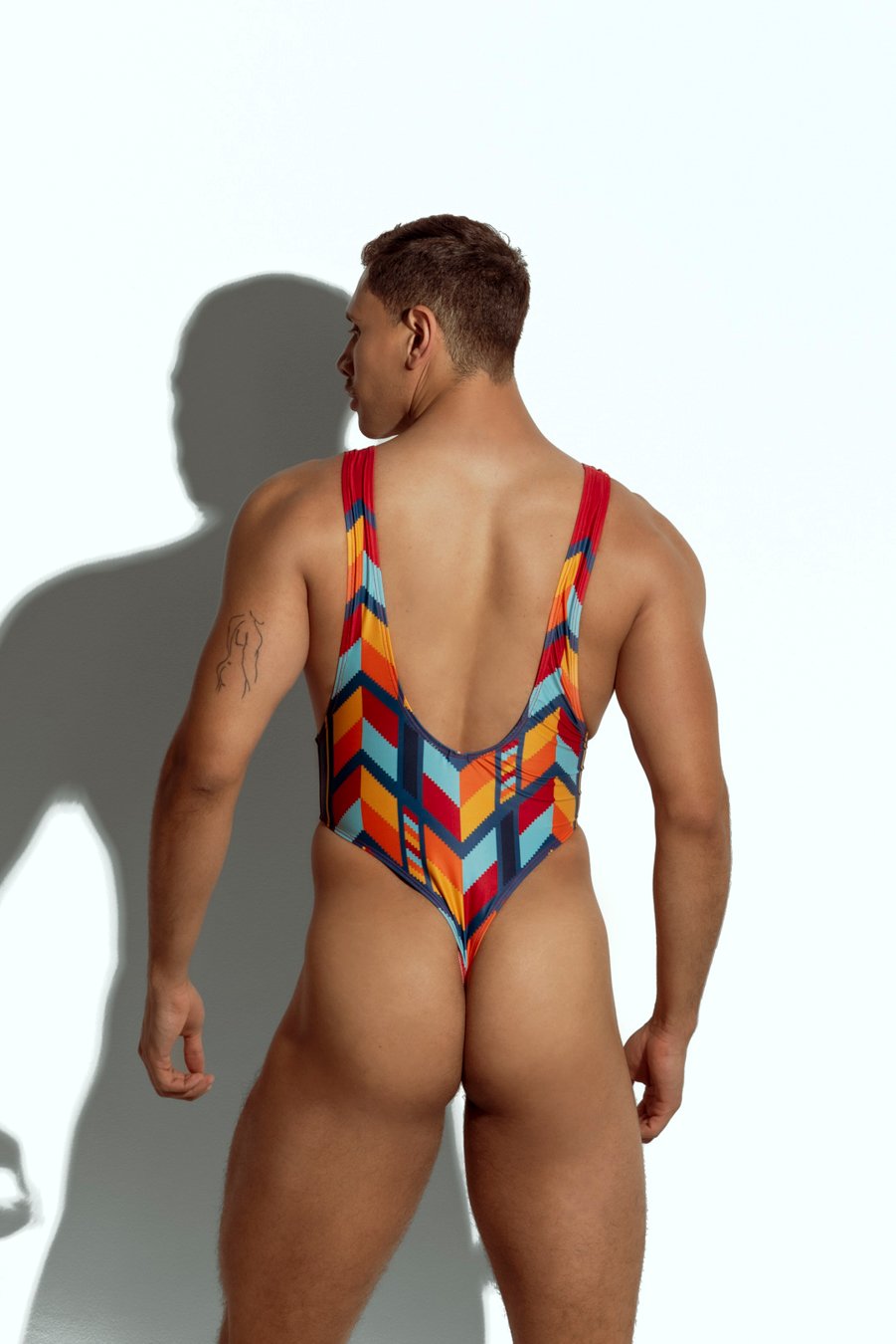 Men's high-cut swim bodysuit with orange and teal geometric pattern, designed for gay men seeking bold and fashionable swimwear