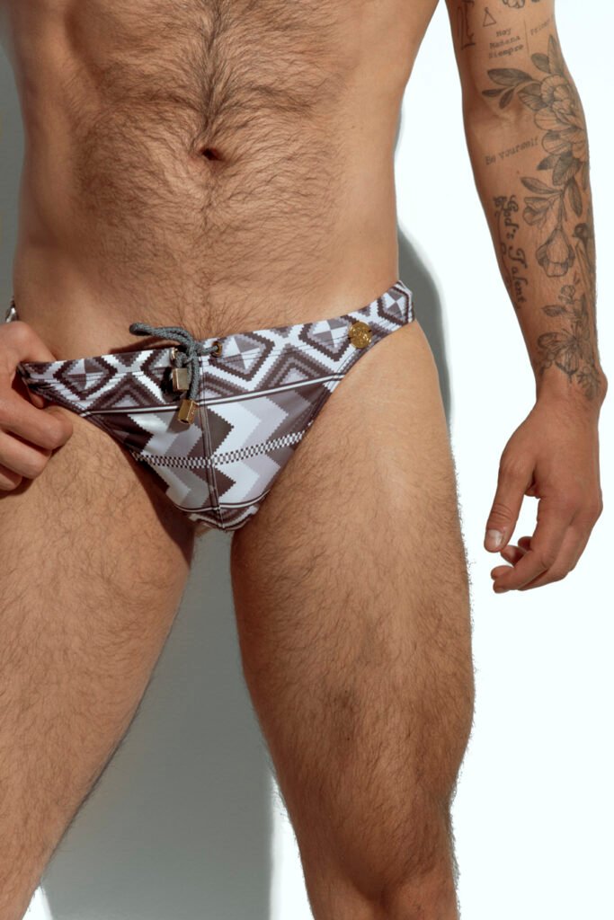 Men's thong with tribal geometric print in neutral tones, designed for gay men seeking bold and sexy swimwear