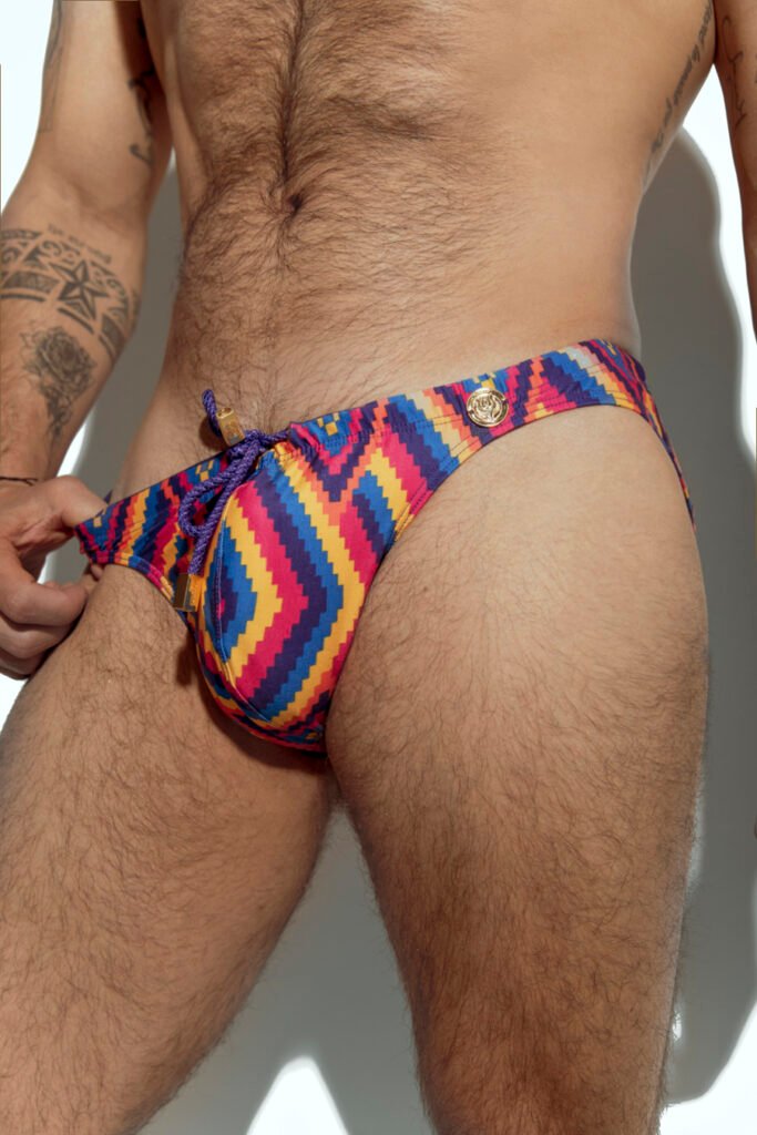 Men's swim brief with vibrant rainbow stripe pattern, designed for gay men looking for bold and colorful beachwear