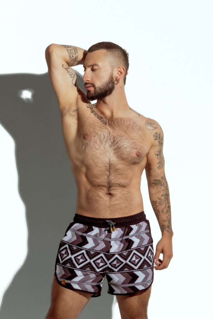 Men's swim short with tribal geometric print in neutral tones, designed for gay men seeking bold and sexy swimwear