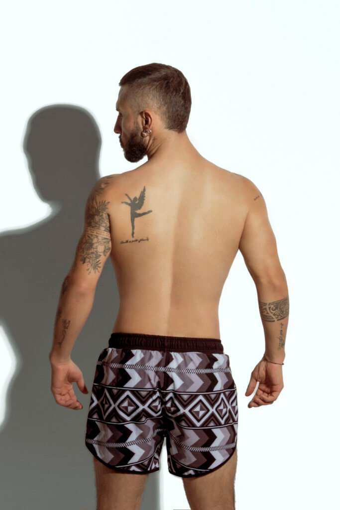 Men's swim short with tribal geometric print in neutral tones, designed for gay men seeking bold and sexy swimwear