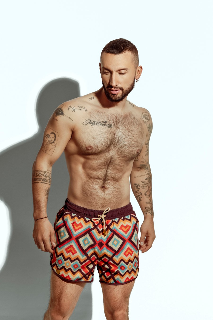 Men's swim short featuring a bold zigzag pattern in red, orange, and yellow, ideal for gay men seeking stylish and eye-catching swimwear