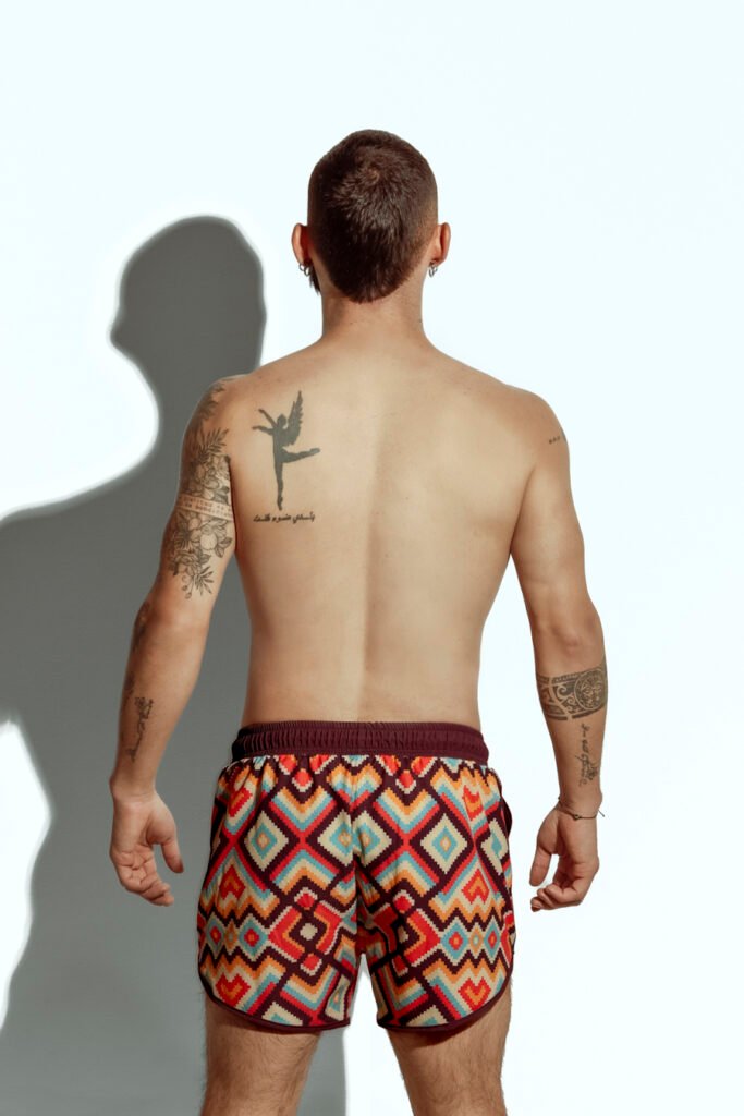 Men's swim short featuring a bold zigzag pattern in red, orange, and yellow, ideal for gay men seeking stylish and eye-catching swimwear