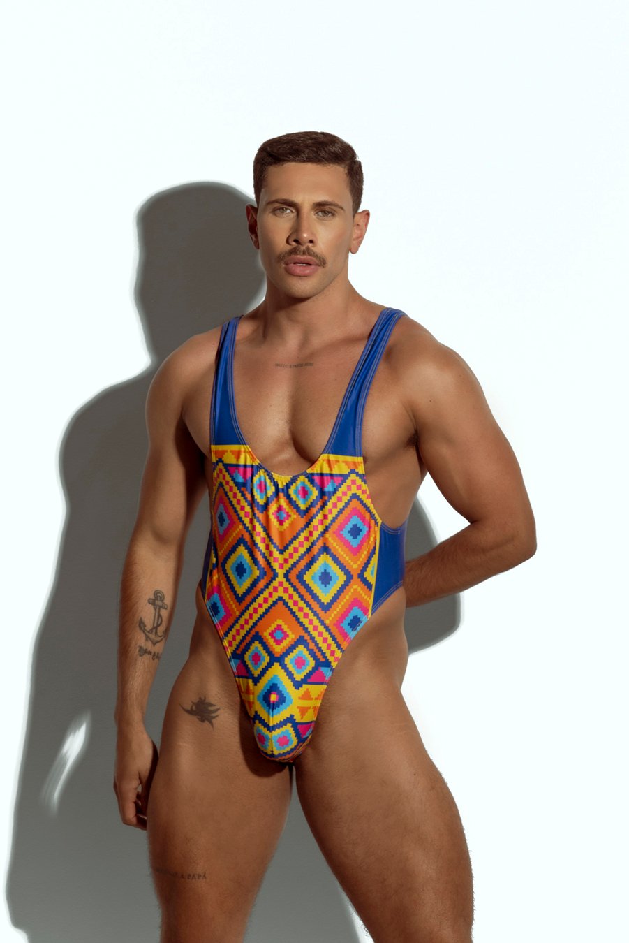 Men's high-cut swim bodysuit with vibrant geometric pattern in multicolor, perfect for gay men seeking bold and eye-catching swimwear