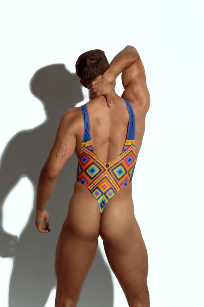 Men's high-cut swim bodysuit with vibrant geometric pattern in multicolor, perfect for gay men seeking bold and eye-catching swimwear