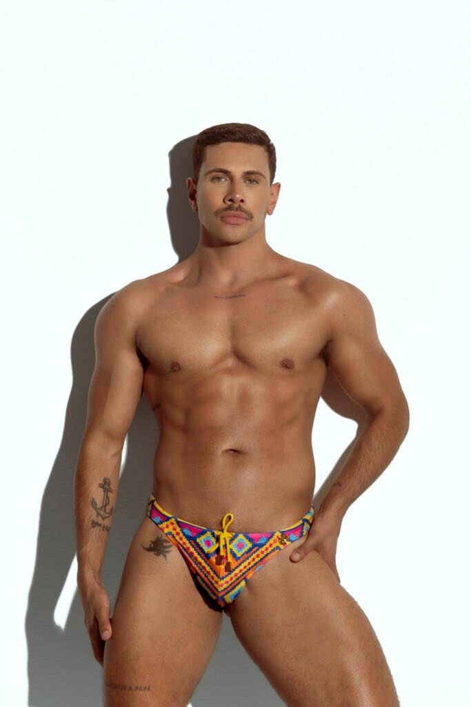 Men's thong swimwear with colorful geometric pattern, ideal for gay men seeking bold and stylish beachwear