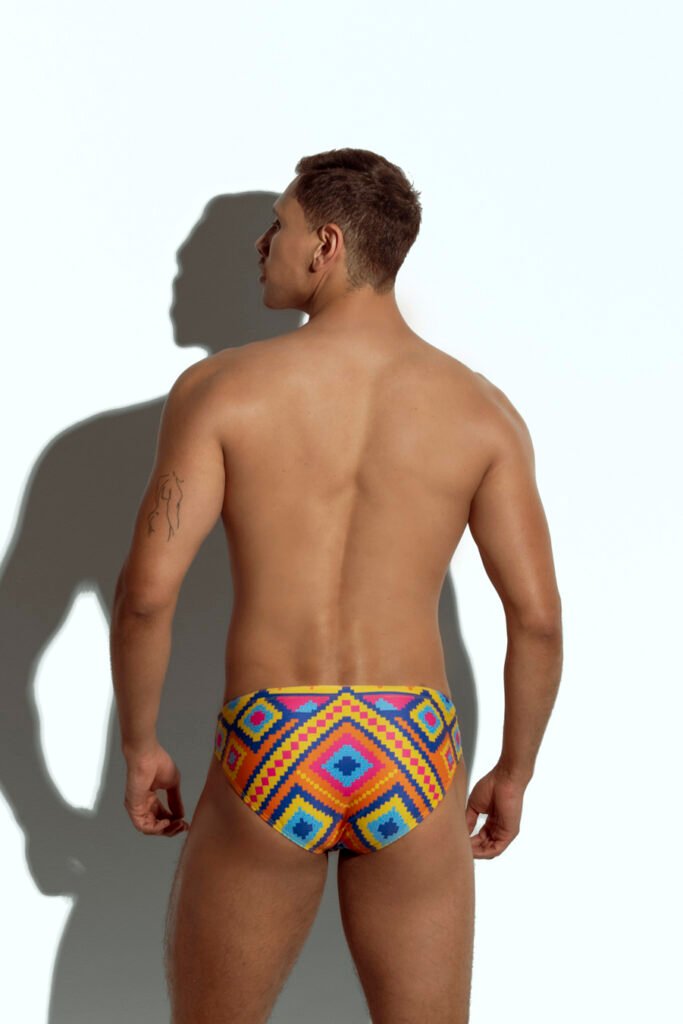 Men's vibrant geometric print swim brief for gay men, bold and colorful design, perfect for making a statement at the beach or pool