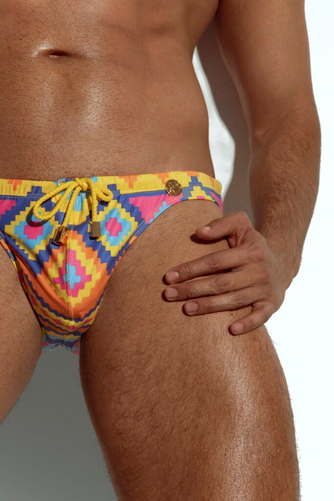 Men's vibrant geometric print swim brief for gay men, bold and colorful design, perfect for making a statement at the beach or pool