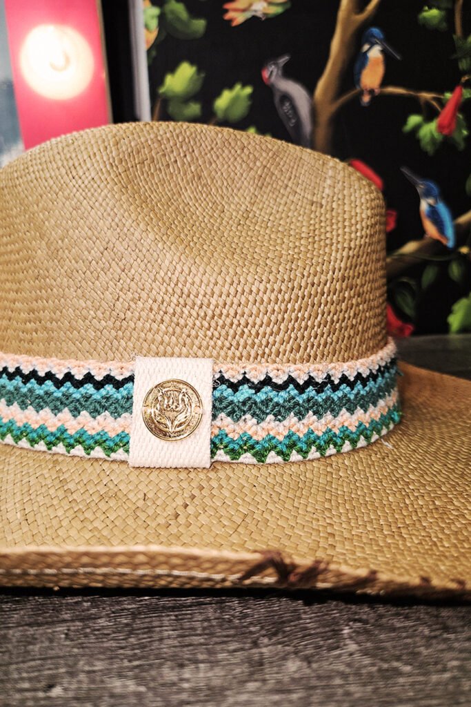 Handmade straw hat with vibrant Wayuu band by Colombian artisans. Perfect for beach, poolside relaxation, or summer cocktails. Stylish and unique